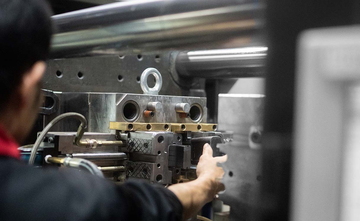 engineer removing plastic product from metal mould tool